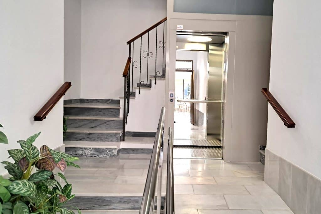 Vestíbulo de entrada del centro, con escalera y ascensor de acceso a las consultas