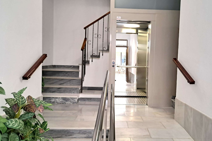 Vestíbulo de entrada del centro, con escalera y ascensor de acceso a las consultas